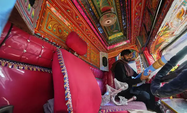 Driver Farrukh Sana checks items inside the cabin of a newly refurbished truck painted with traditional artwork at a yard for workshops in Rawalpindi, Pakistan, Monday, April 21, 2025. (AP Photo/Anjum Naveed)