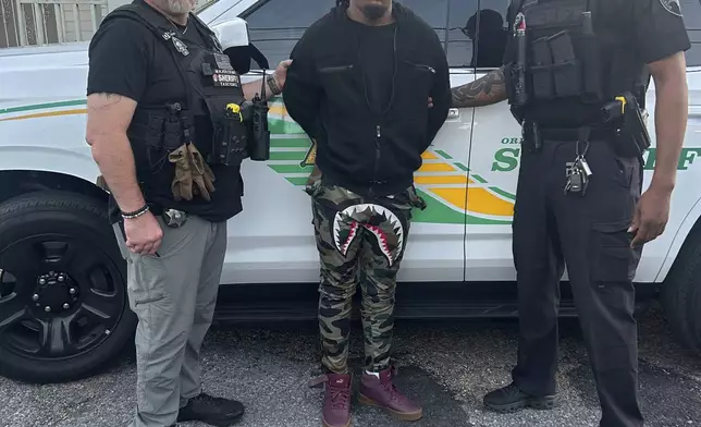 This photo provided by the Orleans Parish Sheriff's Office shows escaped inmate Robert Moody, center flanked by Detective Charles Morgan, left, and Detective Bryant Parish, right, after he had been captured in New Orleans on Friday May, 16, 2025. ( Orleans Parish Sheriff's Office via AP)