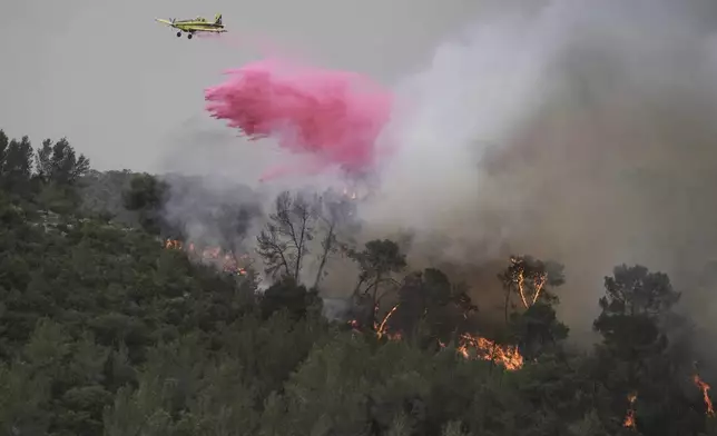 A plane uses a fire retardant to extinguish a fire burning in a forest near Jerusalem, Wednesday, April 30, 2025. (AP Photo/Mahmoud Illean)
