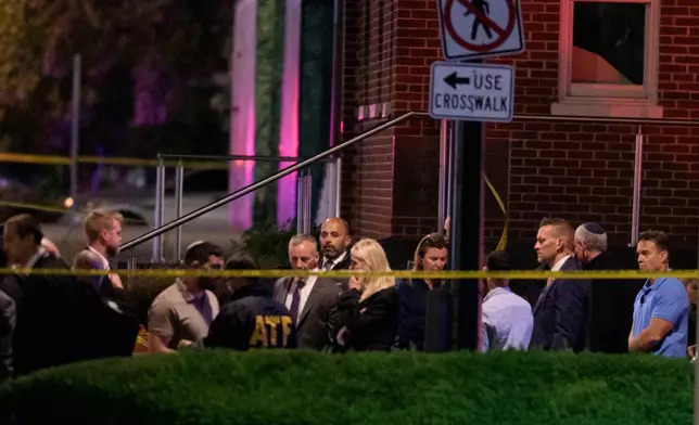 Attorney General Pam Bondi, center, walks to her car as law enforcement work the scene after two staff members of the Israeli Embassy in Washington were shot and killed outside the Capital Jewish Museum, Thursay, May 22, 2025, in Washington. (AP Photo/Rod Lamkey, Jr.)