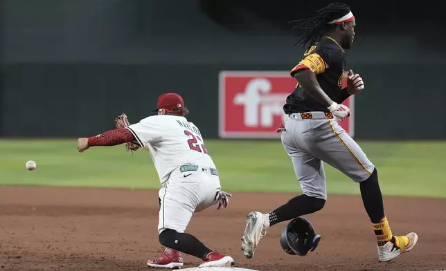 Arizona Diamondbacks first baseman Josh Naylor, left, is unable to make a play on a throwing error by Diamondbacks shortstop Geraldo Perdomo as Pittsburgh Pirates' Oneil Cruz, right, reaches first base safely during the eighth inning of a baseball game Tuesday, May 27, 2025, in Phoenix. (AP Photo/Ross D. Franklin)