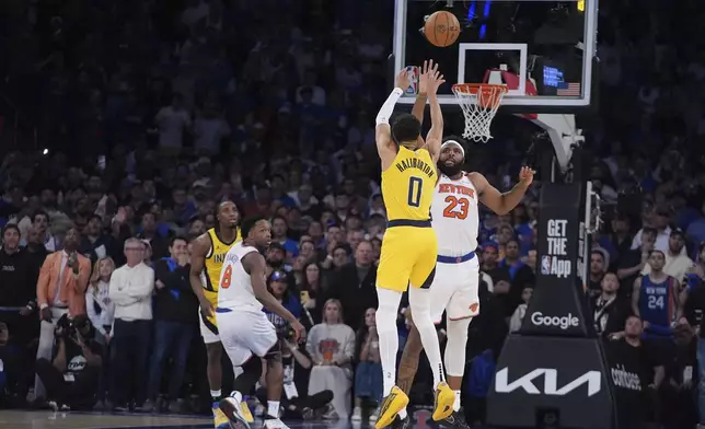 Indiana Pacers guard Tyrese Haliburton (0) shoots a 2-point shot against New York Knicks center Mitchell Robinson (23) to tie the score at the end of regulation in Game 1 of the NBA basketball Eastern Conference final, Wednesday, May 21, 2025, in New York. (AP Photo/Frank Franklin II)