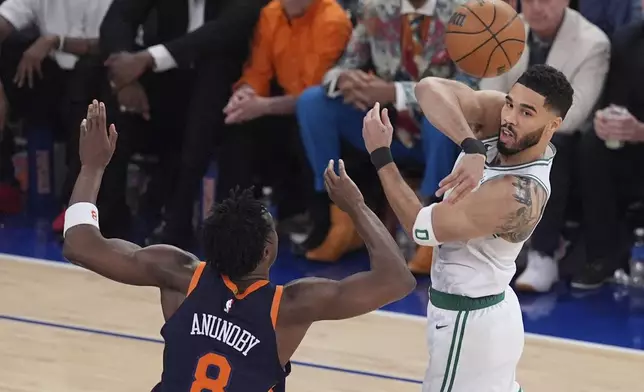 Boston Celtics' Jayson Tatum (0) passes away from New York Knicks' OG Anunoby (8) during the first half of Game 4 in the Eastern Conference semifinals of the NBA basketball playoffs Monday, May 12, 2025, in New York. (AP Photo/Frank Franklin II)