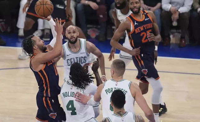 New York Knicks' Jalen Brunson, left, shoots over Boston Celtics' Jrue Holiday (4) and Derrick White (9) during the first half of Game 4 in the Eastern Conference semifinals of the NBA basketball playoffs Monday, May 12, 2025, in New York. (AP Photo/Frank Franklin II)