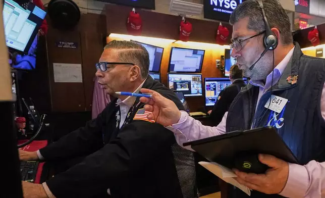 Traders Jonathan Mueller, left, and Michael Capolino work on the floor of the New York Stock Exchange, Wednesday, May 7, 2025. (AP Photo/Richard Drew)