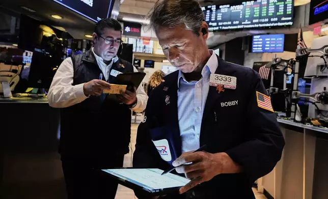 Traders Michael Capolino, left, and Robert Charmak work on the floor of the New York Stock Exchange, Monday, May 12, 2025. (AP Photo/Richard Drew)
