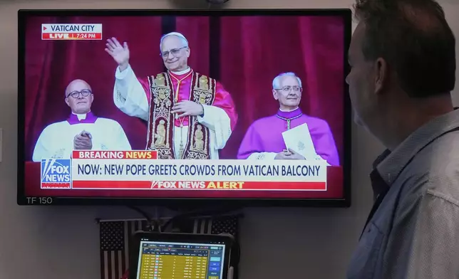 Trader Bob Hannan watches a television screen on the trading floor of the New York Stock Exchange as newly elected Pope Leo XIV appears at the balcony of St. Peter's Basilica at the Vatican, Thursday, May 8, 2025. (AP Photo/Richard Drew)