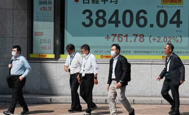 People walk in front of an electronic stock board showing Japan's Nikkei index at a securities firm Tuesday, May 13, 2025, in Tokyo. (AP Photo/Eugene Hoshiko)