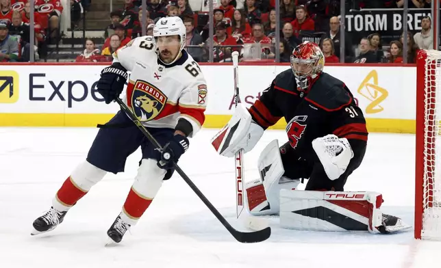 Florida Panthers' Brad Marchand (63) skates in front of Carolina Hurricanes goaltender Frederik Andersen (31) during the first period of Game 5 of the NHL hockey Stanley Cup Eastern Conference finals in Raleigh, N.C., Wednesday, May 28, 2025. (AP Photo/Karl DeBlaker)
