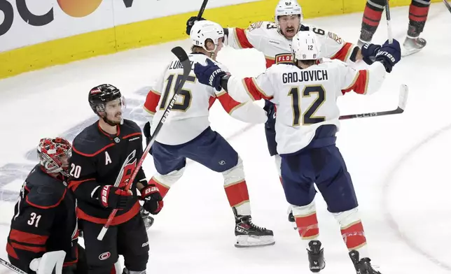 Florida Panthers center Anton Lundell (15) celebrates his goal with center Brad Marchand, top right, and left wing Jonah Gadjovich (12) while Carolina Hurricanes goaltender Frederik Andersen (31) and center Sebastian Aho (20) react during the second period in Game 5 of the NHL hockey Stanley Cup Eastern Conference finals Wednesday, May 28, 2025, in Raleigh, N.C. (AP Photo/Chris Seward)