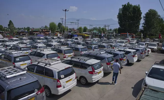 A Kashmiri taxi driver walks past hundreds of tourist cabs parked idle in Srinagar, Indian controlled Kashmir, India, Tuesday, May 20, 2025. (AP Photo/Dar Yasin)