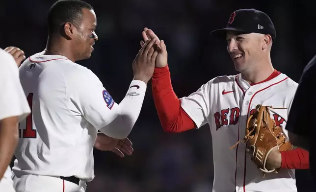 Boston Red Sox third base Alex Bregman, right, celebrates with Rafael Devers, left, after defeating the Minnesota Twins in a baseball game at Fenway Park, Friday, May 2, 2025, in Boston. (AP Photo/Charles Krupa)