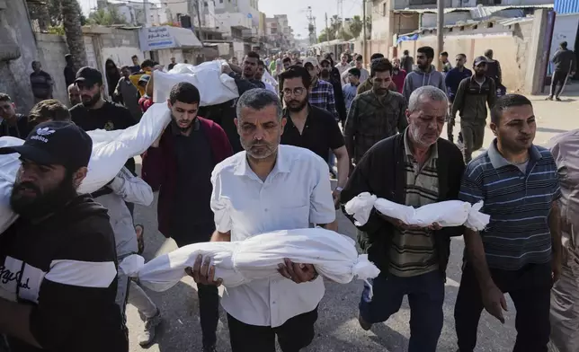 Palestinian carry the bodies of their relatives including children who were killed in an Israeli army airstrike in Deir al-Balah, Gaza, Wednesday, May 21, 2025. (AP Photo/Abdel Kareem Hana)