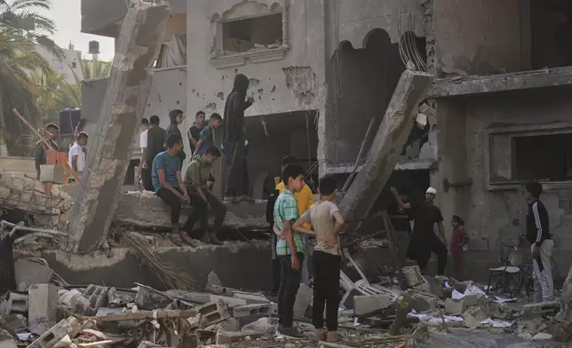 Palestinians inspect a house destroyed by an Israeli airstrikes in Deir al-Balah, Gaza, Wednesday, May 21, 2025. (AP Photo/Abdel Kareem Hana)