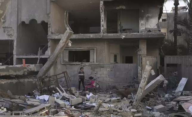 Palestinians inspect a house destroyed by an Israeli airstrikes in Deir al-Balah, Gaza, Wednesday, May 21, 2025. (AP Photo/Abdel Kareem Hana)
