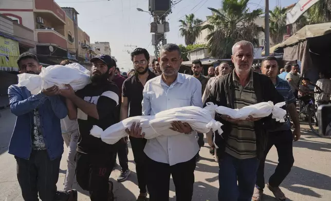 Palestinian carry the bodies of their relatives including children who were killed in an Israeli army airstrike in Deir al-Balah, Gaza, Wednesday, May 21, 2025. (AP Photo/Abdel Kareem Hana)