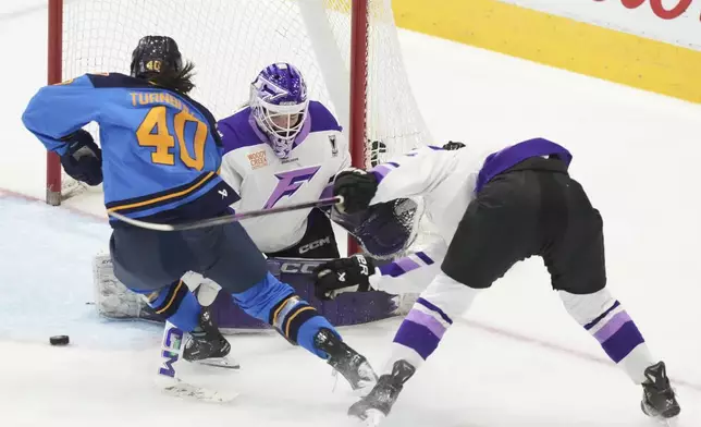 Toronto Sceptres' Blayre Turnbull, left, trips over the stick of Minnesota Frost goaltender Maddie Rooney during second-period PWHL playoff hockey game action in Toronto, Friday, May 9, 2025. (Chris Young/The Canadian Press via AP)