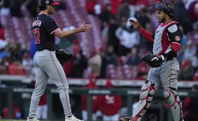 Washington Nationals pitcher Kyle Finnegan, left, catcher Keibert Ruiz, right, celebrate after winning a baseball game against the Cincinnati Reds, Sunday, May 4, 2025, in Cincinnati. (AP Photo/Carolyn Kaster)