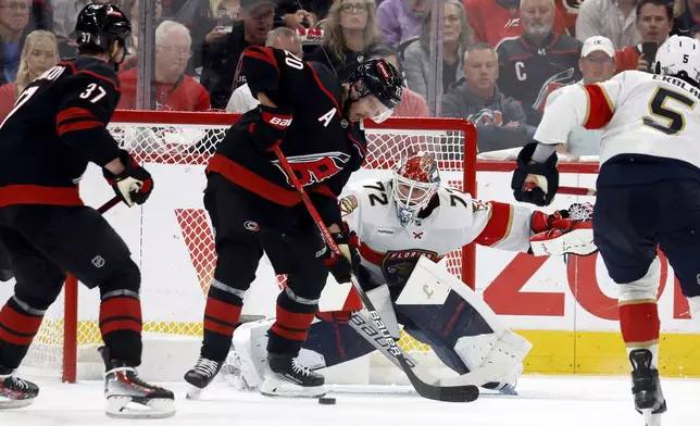 Carolina Hurricanes' Sebastian Aho (20) redirects the puck past Florida Panthers goaltender Sergei Bobrovsky (72) with Andrei Svechnikov (37) nearby during the first period of Game 1 of the NHL hockey Stanley Cup Eastern Conference finals in Raleigh, N.C., Tuesday, May 20, 2025. (AP Photo/Karl DeBlaker)