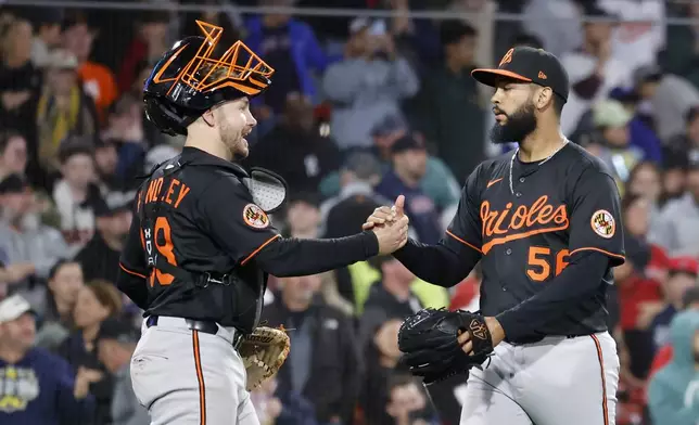 Baltimore Orioles pitcher Seranthony Dominguez (56) is congratulated by catcher Maverick Handley after getting the last out during the ninth inning of the second baseball game of a doubleheader against the Boston Red Sox, Saturday, May 24, 2025, at Fenway Park in Boston. (AP Photo/Mary Schwalm)