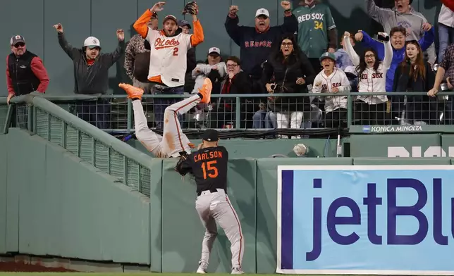 Baltimore Orioles outfielder Jorge Mateo falls into the bullpen unable to make the catch as Dylan Carlson (15) looks on a home run by Boston Red Sox's Abraham Toro during the ninth inning of the second baseball game of a doubleheader, Saturday, May 24, 2025, at Fenway Park in Boston. (AP Photo/Mary Schwalm)