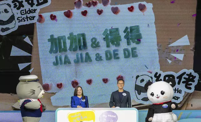 The name of the Hong Kong-born giant panda twin cubs Jia Jia and De De are displayed on the screen as Rosanna Law, secretary for Culture, Sports and Tourism of Hong Kong, left and Paulo Pong, chairman of the Ocean Park attend the naming ceremony in Hong Kong, Tuesday, May 27, 2025. (AP Photo/Chan Long Hei)
