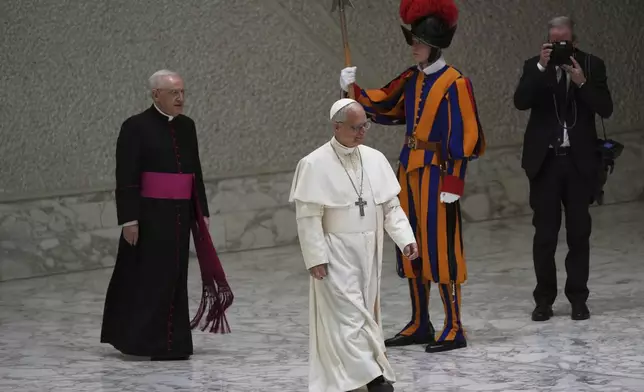 Pope Leo XIV arrives as he meets members of the international media in the Paul VI Hall at the Vatican, Tuesday, May 13, 2025. (AP Photo/Domenico Stinellis)