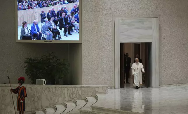 Pope Leo XIV arrives as he meets members of the international media in the Paul VI Hall at the Vatican, Tuesday, May 13, 2025. (AP Photo/Domenico Stinellis)