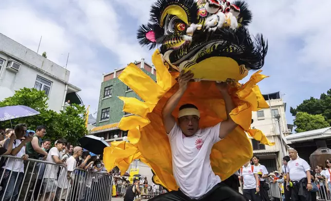 A participant performs lion dance in the Piu Sik Parade at the Bun Festival in Cheung Chau Island in Hong Kong, Monday, May 5, 2025. (AP Photo/Chan Long Hei)