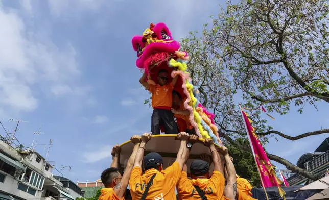 Participants perform lion dance in the Piu Sik Parade at the Bun Festival in Cheung Chau Island in Hong Kong, Monday, May 5, 2025. (AP Photo/Chan Long Hei)