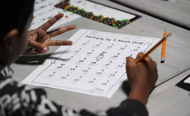 A second grader uses his hands to do math at Place Bridge Academy, May 20, 2025, in Denver. (AP Photo/Rebecca Slezak)