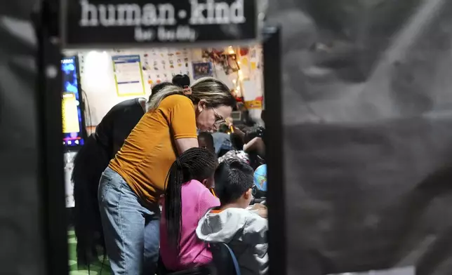 Classroom aid Zhour Boutyebi works with students in a second grade math class at Place Bridge Academy, May 20, 2025, in Denver. (AP Photo/Rebecca Slezak)