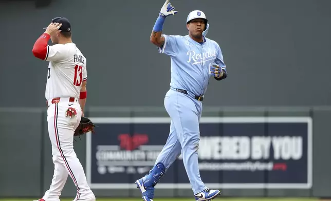 Kansas City Royals designated hitter Salvador Perez, right, celebrates his RBI single against the Minnesota Twins during the fifth inning of baseball game Saturday, May 24, 2025, in Minneapolis. (AP Photo/Matt Krohn)