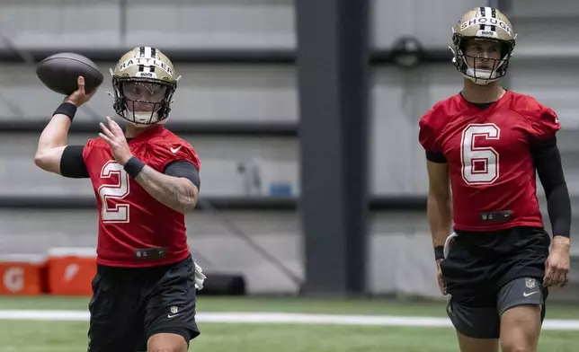 New Orleans Saints quarterback Spencer Rattler (2) throws next to quarterback Tyler Shough (6) during NFL football practice in Metairie, La., Thursday, May 22, 2025. (AP Photo/Matthew Hinton)