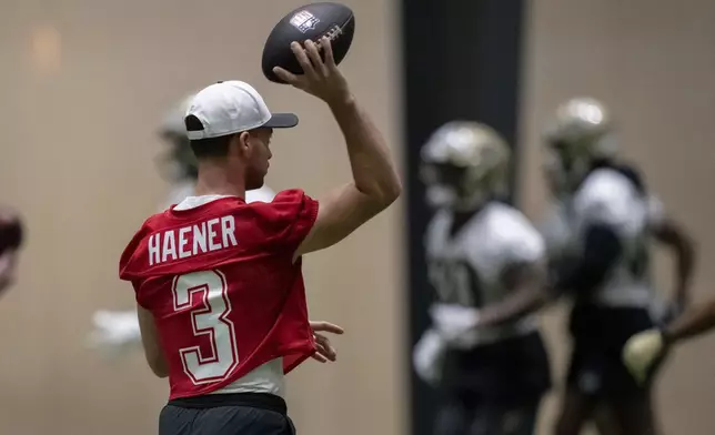 New Orleans Saints quarterback Jake Haener (3) tosses during NFL football practice in Metairie, La., Thursday, May 22, 2025. (AP Photo/Matthew Hinton)