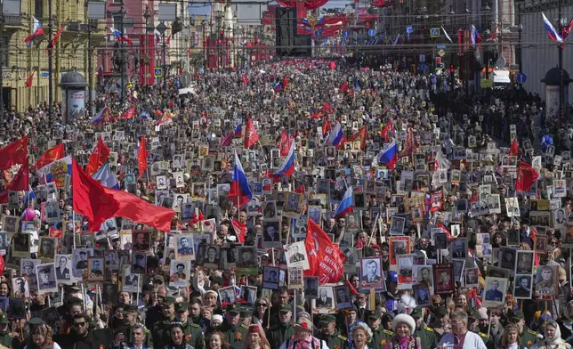 People carry portraits of relatives who fought in World War II, during the Immortal Regiment march at the Nevsky prospect, the central avenue of St. Petersburg, Russia, Friday, May 9, 2025, during celebrations of the 80th anniversary of the Soviet Union's victory over Nazi Germany during the World War II. (AP Photo/Dmitri Lovetsky)