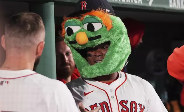 Boston Red Sox designated hitter Rafael Devers celebrates in the dugout after his solo home run during the fifth inning of a baseball game against the New York Mets at Fenway Park, Tuesday, May 20, 2025, in Boston. (AP Photo/Charles Krupa)