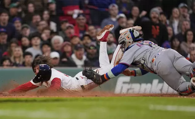 Boston Red Sox's Nick Sogard, left, is tagged out by New York Mets catcher Francisco Alvarez while trying to score on a line out by Carlos Narvaez during the second inning of a baseball game at Fenway Park, Tuesday, May 20, 2025, in Boston. (AP Photo/Charles Krupa)
