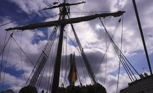 Visitors are silhouetted as they tour the 93ft Nao Santa Maria a replica of the boat sailed on by Christopher Columbus, anchored at St Katharine Docks in London, Thursday, May 29, 2025, open to visitors from May 29 until June 8. (AP Photo/Kirsty Wigglesworth)