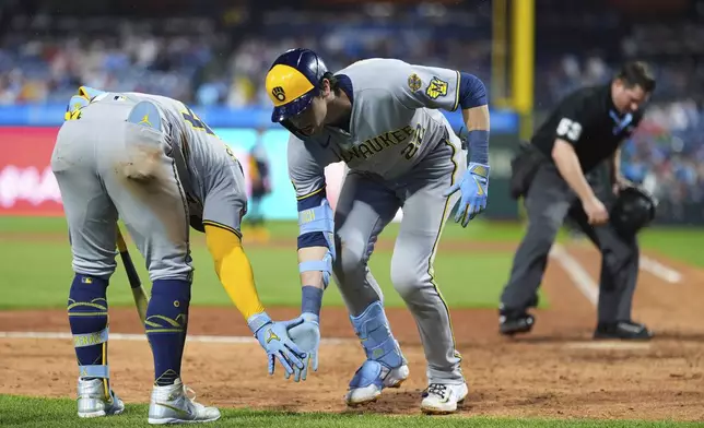 Milwaukee Brewers' Christian Yelich, center, celebrates with William Contreras after hitting a home run during the ninth inning of a baseball game against the Philadelphia Phillies Friday, May 30, 2025, in Philadelphia. (AP Photo/Matt Slocum)