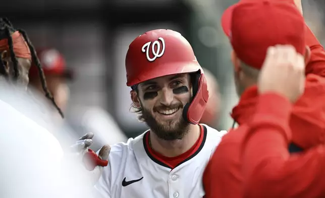 Washington Nationals' Dylan Crews is greeted in the dugout by teammates after hitting a solo home run against Atlanta Braves pitcher Spencer Strider during the second inning of a baseball game in Washington, Tuesday, May 20, 2025. (AP Photo/Terrance Williams)