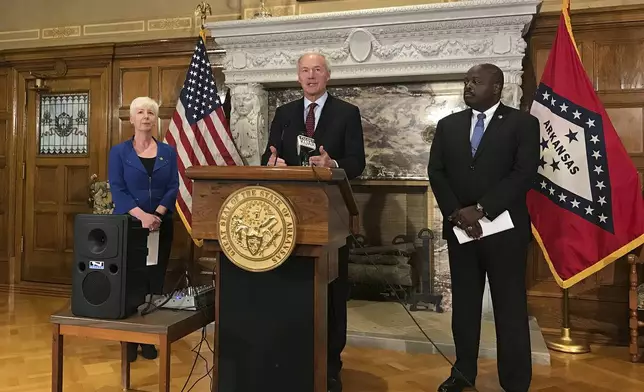 FILE - In this Sept. 12, 2018, file photo, Arkansas Gov. Asa Hutchinson, center, talks at a news conference at the State Capitol in Little Rock, Ark., about the state's work requirement for its expanded Medicaid program. (AP Photo/Andrew DeMillo, File)