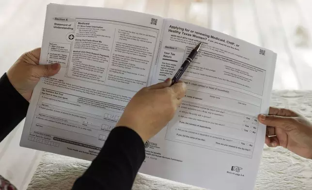 FILE - Children's Defense Fund Program Director Graciela Camarena assists Lucia Salazar with filling out Medicaid and SNAP application forms for her family in Pharr, Texas, Nov. 13, 2023. (AP Photo/Michael Gonzalez, File)