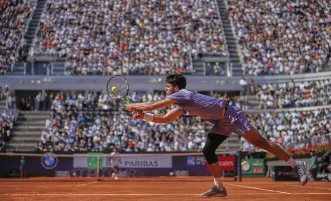 Spain's Carlos Alcaraz returns the ball to Italy's Lorenzo Musetti during their semifinal tennis match at the Italian Open, at the Foro Italico, in Rome, Friday, May 16, 2025. (AP Photo/Andrew Medichini)