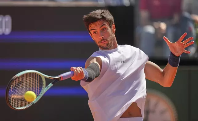 Italy's Lorenzo Musetti returns the ball to Spain's Carlos Alcaraz during their semifinal tennis match at the Italian Open, at the Foro Italico, in Rome, Friday, May 16, 2025. (AP Photo/Andrew Medichini)