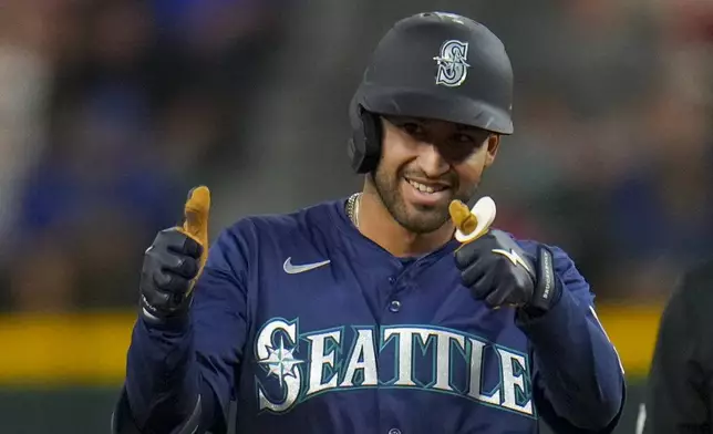 Seattle Mariners' Rhylan Thomas reacts after collecting his first major league hit during his debut in the fifth inning of a baseball game against the Texas Rangers Friday, May 2, 2025, in Arlington, Texas. (AP Photo/Julio Cortez)
