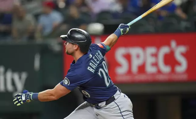 Seattle Mariners' Cal Raleigh follows through while hitting a grand slam against the Texas Rangers during the fifth inning of a baseball game Friday, May 2, 2025, in Arlington, Texas. (AP Photo/Julio Cortez)