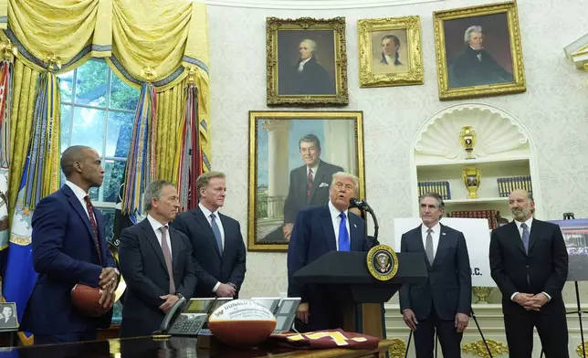 President Donald Trump, third from right, speaks as Commerce Secretary Howard Lutnick, from right, Interior Secretary Doug Burgum, and from left, Secretary of Housing and Urban Development Scott Turner, Washington Commanders owner Josh Harris and NFL Commissioner Roger Goodell listen during an event to announce that the 2027 NFL Draft will be held on the National Mall, in the Oval Office of the White House, Monday, May 5, 2025, in Washington. (AP Photo/Alex Brandon)