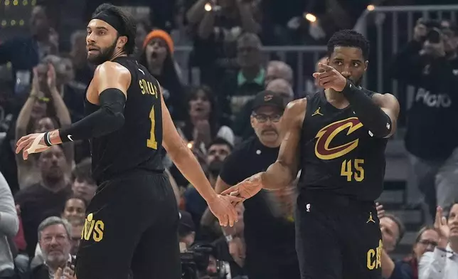 Cleveland Cavaliers guard Donovan Mitchell, right, gestures after scoring and drawing a foul as forward Obi Toppin congratulates him during the first half in Game 5 of an Eastern Conference semifinal NBA basketball playoff Tuesday, May 13, 2025, in Cleveland. (AP Photo/Sue Ogrocki)