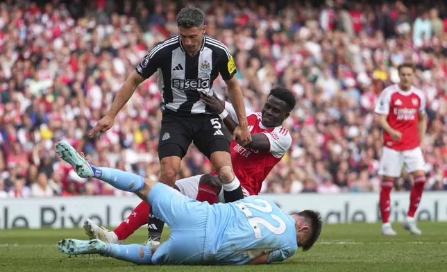 Arsenal's Bukayo Saka challenges for the ball with Newcastle's Fabian Schaer during the English Premier League soccer match between Arsenal and Newcastle United at Emirates stadium in London, Sunday, May 18, 2025. (AP Photo/Kirsty Wigglesworth)
